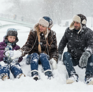 A happy family—father, mother, and child—playing in the snow, representing financial planning and the impact of mortgage pre-approval on credit.