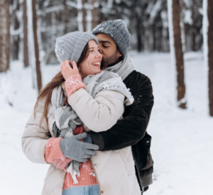 A happy couple embracing and smiling, excited about budgeting and preparing to own their first home.
